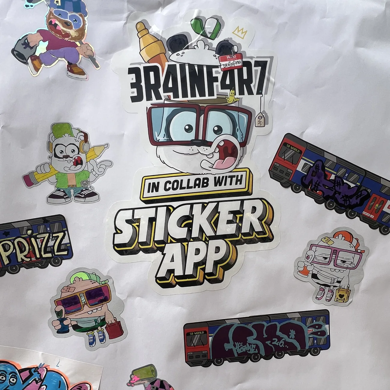 手塗りしたBrainfart x StickerAppのダイカットステッカーと、グラフィティのタグを描いたS8 Worldの電車ラベルで埋め尽くされた壁