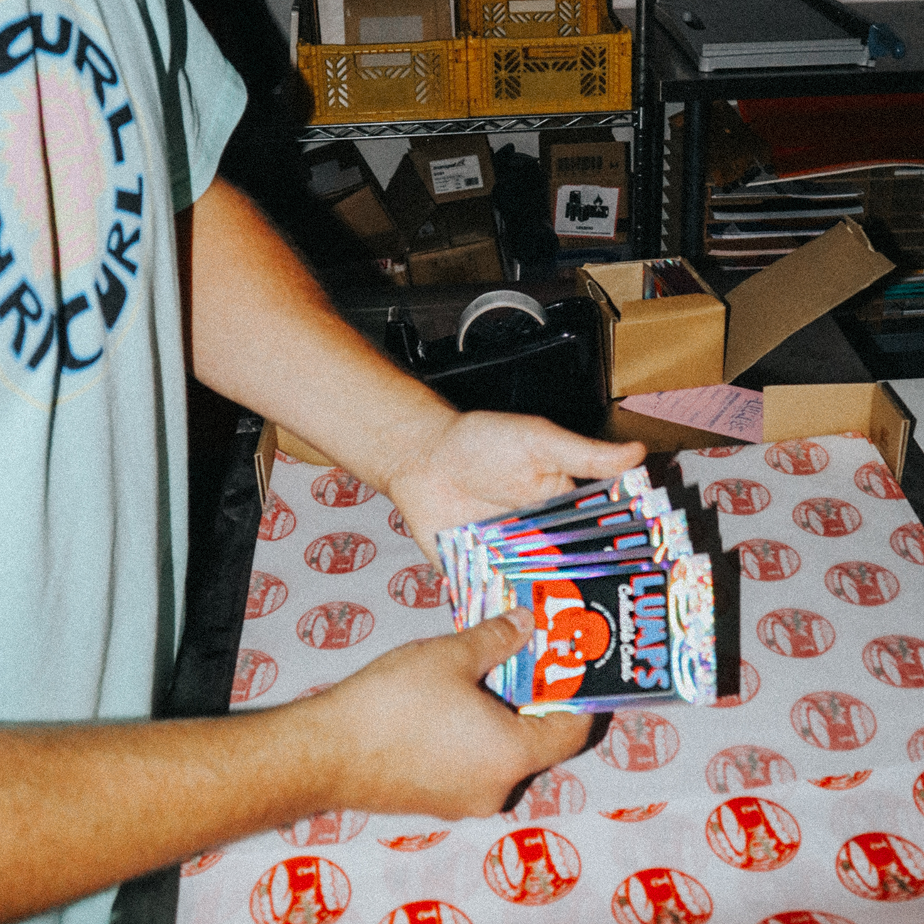 Sam Drew aka Lumps holding collector's cards in his hands, in his art studio.