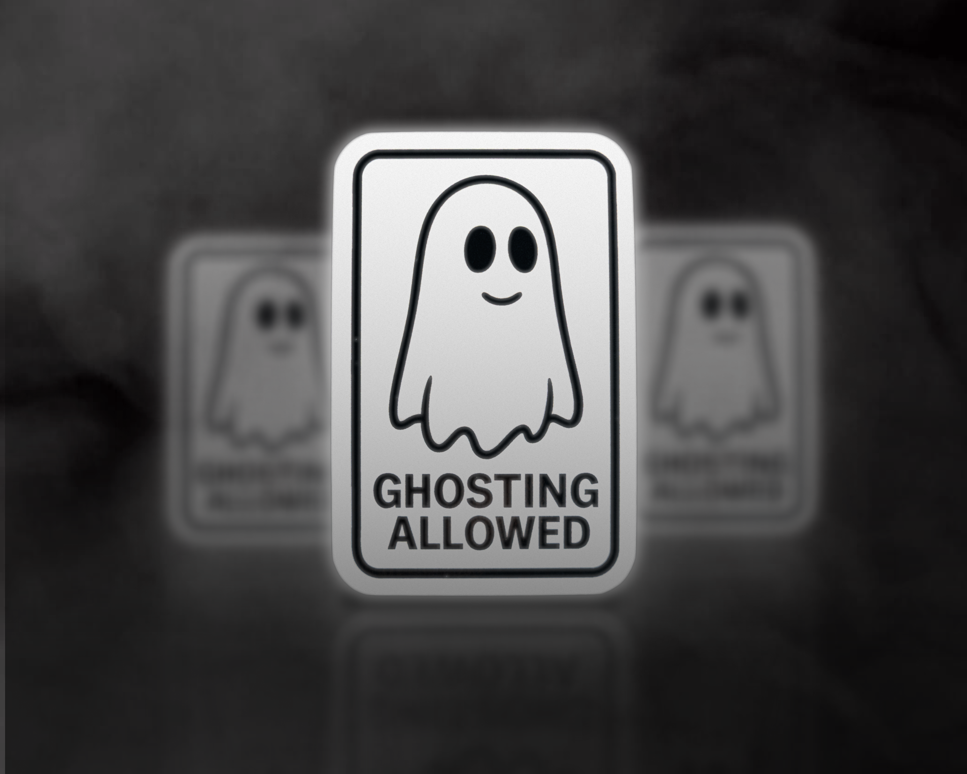 白い背景に「GHOSTING ALLOWED」と書かれたスマイルの幽霊のイラストが描かれた標識。背景にぼやけた同じ標識が見える。