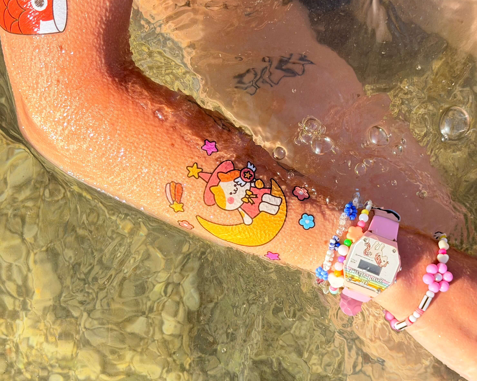 Arm in water with a temporary tattoo on
