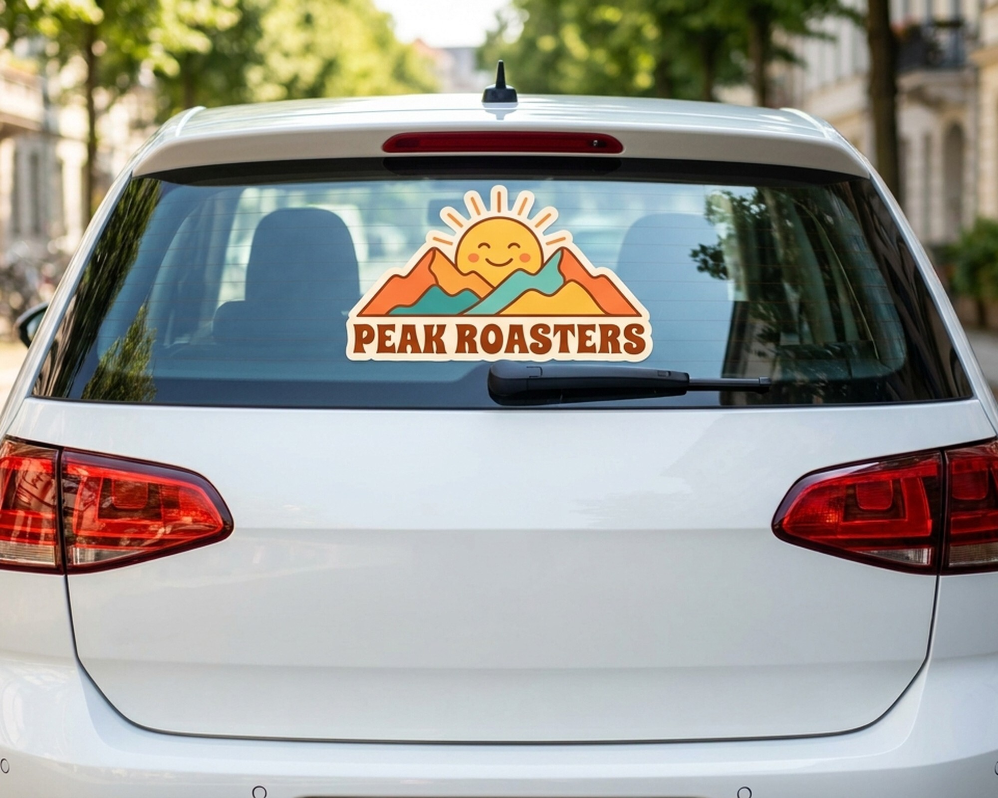 車のリアガラスに貼られた、太陽と山のロゴに「Peak Roasters」の文字入りダイカットのオリジナルデカール