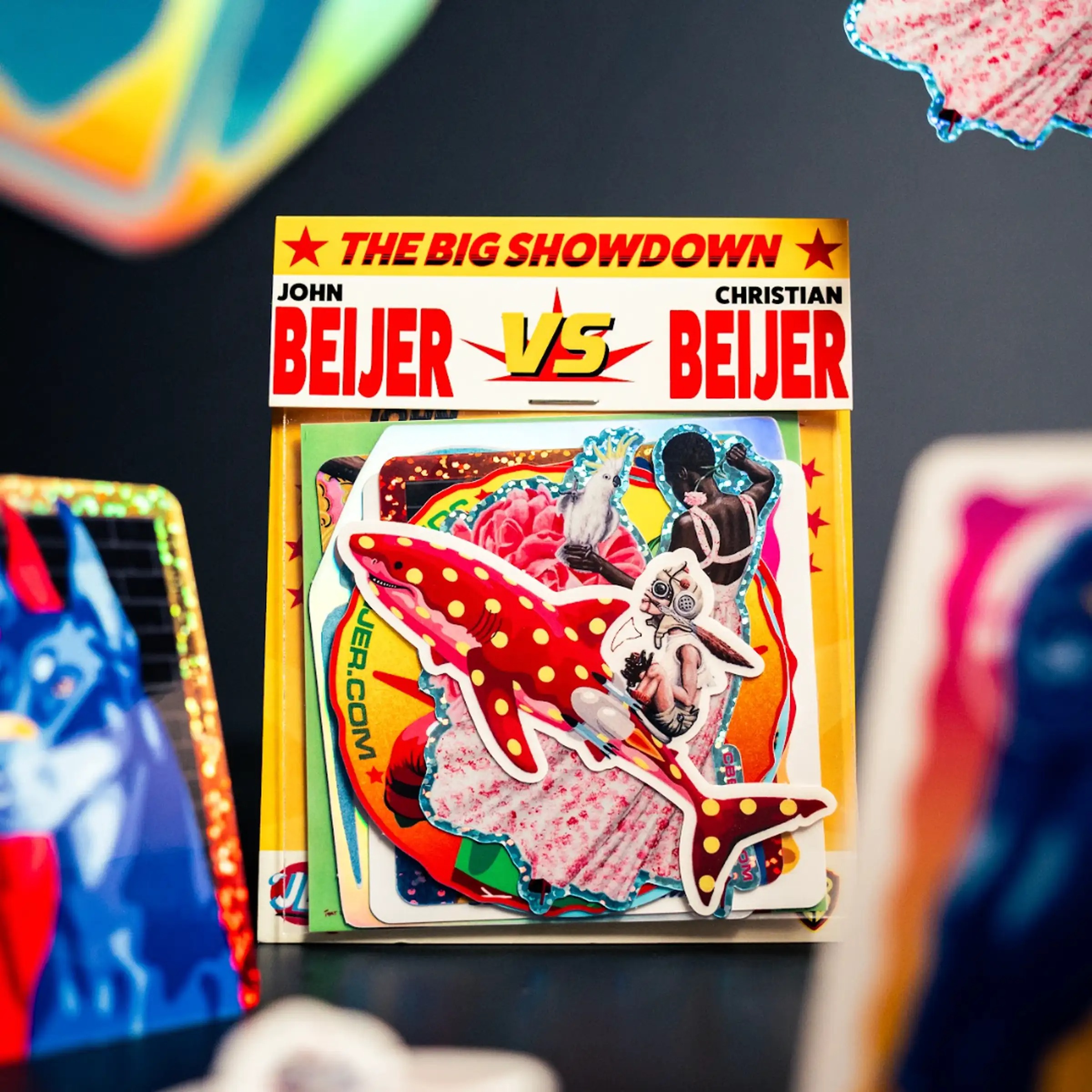 グリッターとホログラムのステッカーが入った、John BeijerとChristian Beijerによる"The Big Showdown"オリジナルステッカーパック