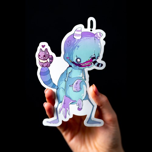 Die cut vinyl sticker of a cute and scary blue creature held by a hand