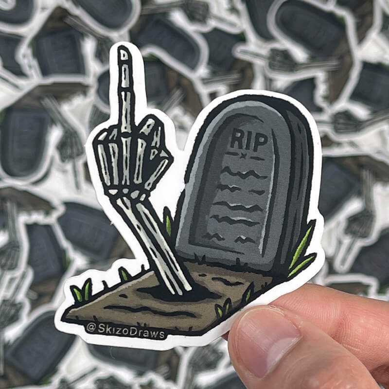 「RIP」と書かれたお墓と、地面から中指を立てる骸骨の腕が描かれた、ビニール素材のダイカットステッカー。背景にはステッカー。